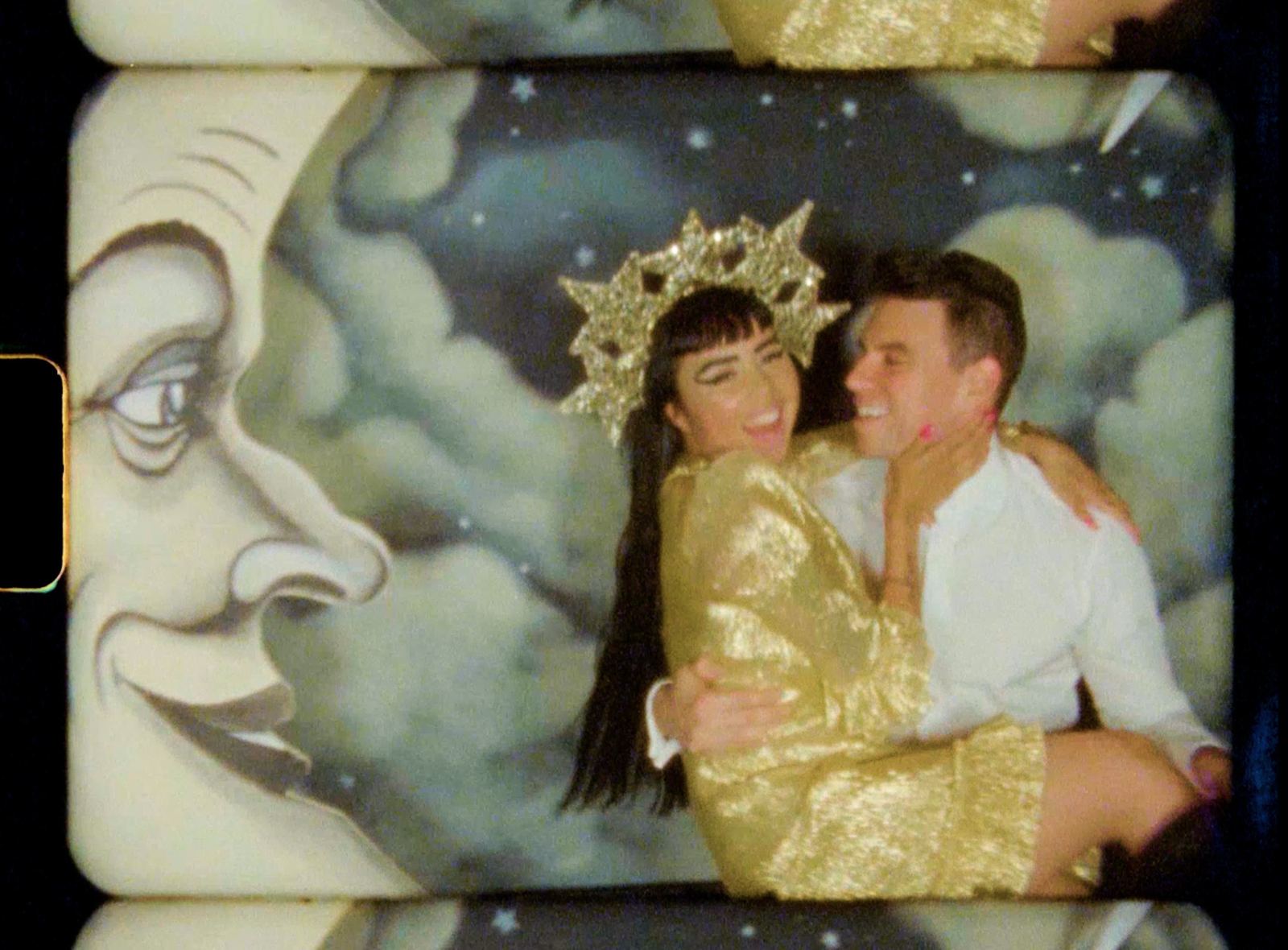 Couple in gold lamé posing with the paper moon