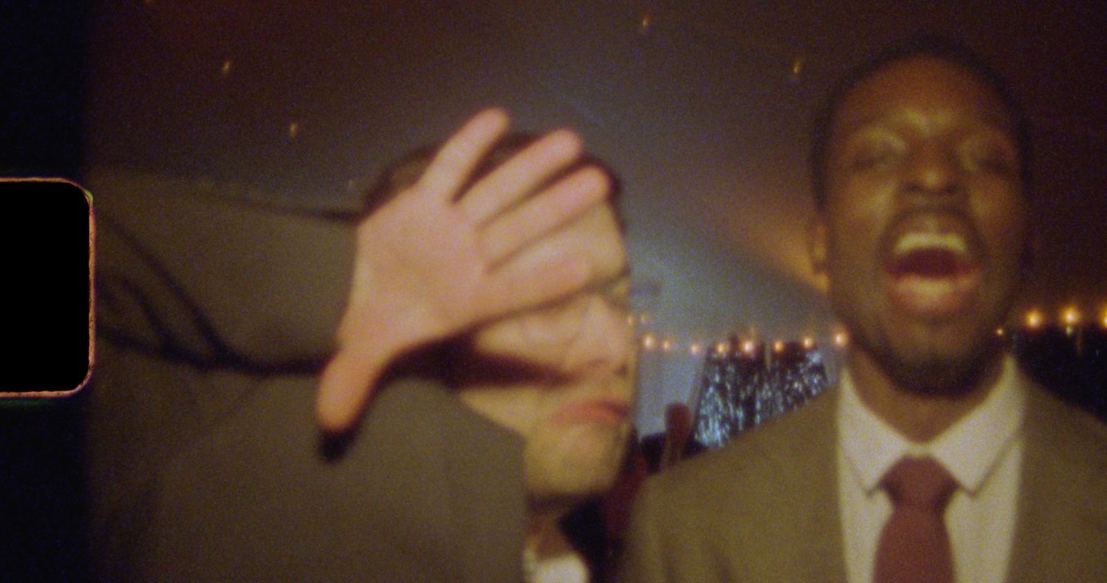 A guest's hand over the lens mid-party
